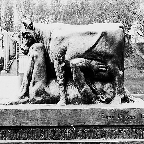 Historická socha muže, který pije kolostrum přímo z vemene krávy.